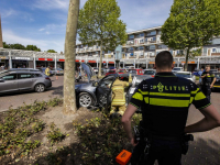 Automobilist rijdt plantsoen in bij winkelcentrum