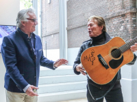 Gitaar van Philip Elzerman van de band The Zipps overhandigd aan Peter Schoon directeur Dordrechts Museum